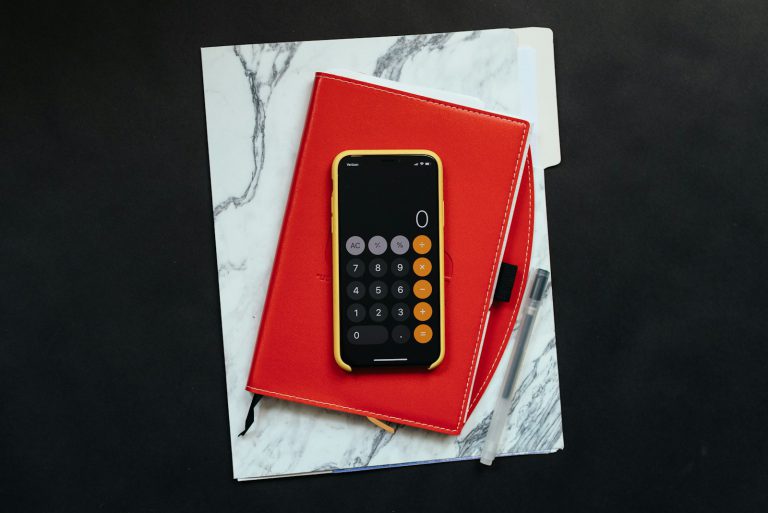 black Android smartphone on red flip case - A retiree reviewing eligibility and benefits of the UK State Pension, planning for financial security in retirement